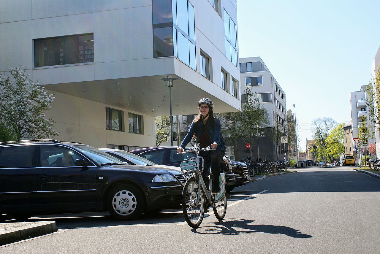 Unsere Referentin für Ökologie & Verkehr, Marie, fährt auf einem nextbike an der Hochschulbibliothek der HTWK vorbei 