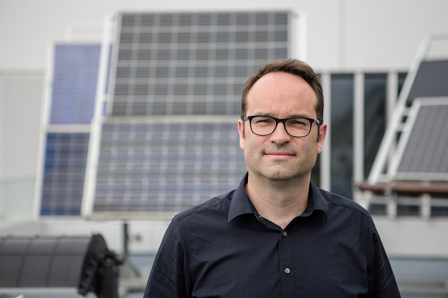 Fährt Rad und dreht die Heizung schonmal runter: Prof. Jens Schneider (Foto: Robert Weinhold/HTWK Leipzig) Mann vor Solarmodulen